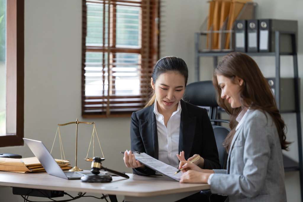 Woman discussing paperwork in an office with attorney