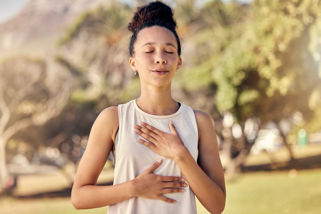 Woman holding her hands to her sternum