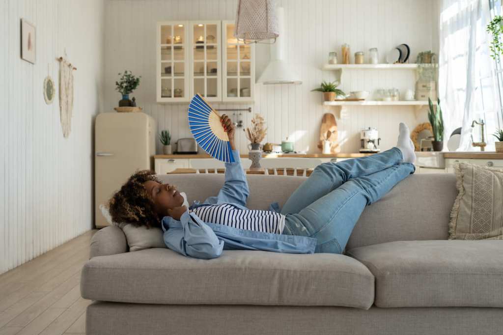 Woman fanning herself on a couch