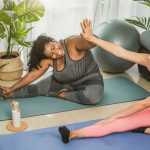 Two women doing yoga and high-fiving