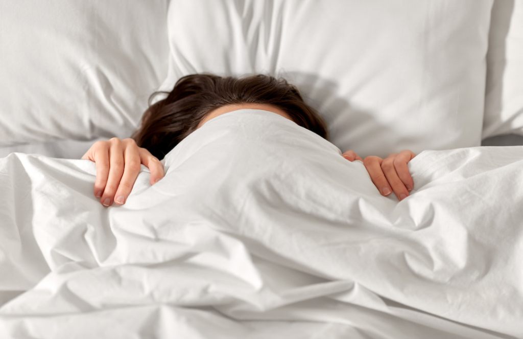 Well Rested Young Couple Stretching on Bed in Morning Stock Photo