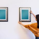 Woman hanging and adjusting pictures