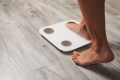 Legs stepping onto a bathroom scale