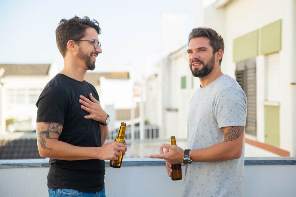 Two men talking outside with drinks