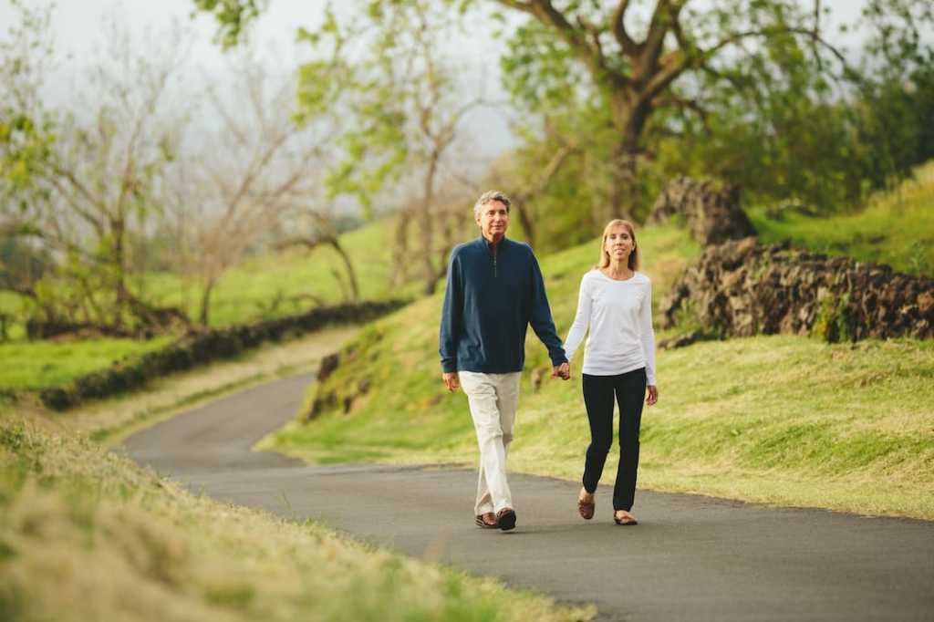Middle-aged couple holding hands on an outdoor walk