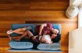 Happy multiethnic lovers resting on sofa and sleeping at home