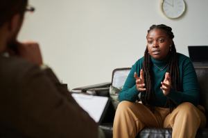 Woman in a blue sweater talking to a therapist