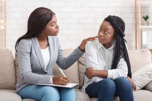 Therapist comforting female client.