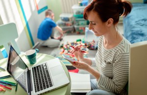 Working mom at her laptop and on her phone who is experiencing functional freeze