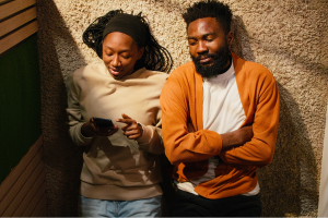 Couple having a close conversation together while looking at their phone