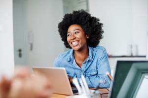 Woman in a denim shirt smiling at work