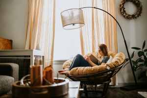 Woman journaling in a comfortable chair by a window