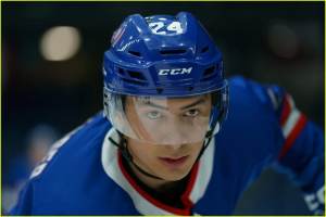 Shane Hollander in blue and white hockey uniform holding a hockey stick on the ice