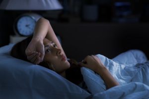 Woman laying bed in a dark room