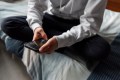 Teen boy in hoodie playing on his phone