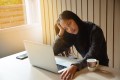 Woman sitting in front of laptop looking anxious