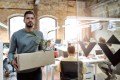 Man quitting his job, walking out with a box of his things