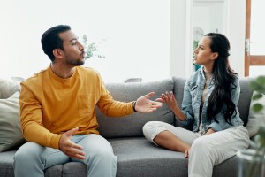 Couple sitting on couch arguing