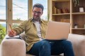 Man in teletherapy session taking notes