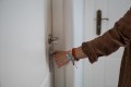 Close up of woman's hand checking the lock on a front door
