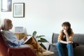 Young woman sitting across from therapist on a couch