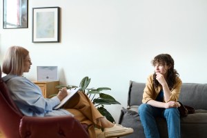 Young woman sitting across from therapist on a couch
