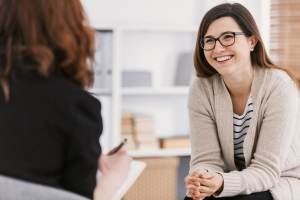 A woman smiling as she talks with her therapist